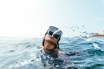 Woman in diving goggles spitting out water, Tenerife, Canary Islands, Spain