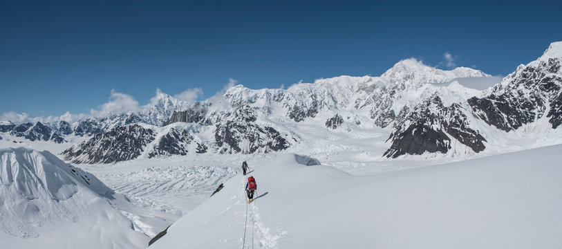 Two climbers descend Explorers Peak in the Ruth Gorge of Denali National Park with Denali in the background.