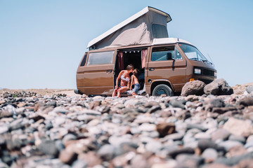 Pulled back view of mum and son kissing in vintage camper van, Tenerife, Canary Islands, Spain