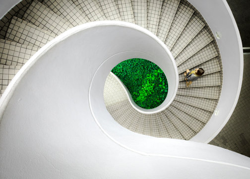 Woman walking up spiral staircase decorated with checked pattern