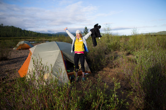 Rising with the morning sun, a woman emerges from the tent excited whilst camping on the shore of the Onon River in northern Mongolia.
