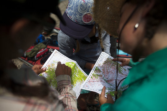 Three women gather for a discussion over maps on the Onon river in northern Mongolia.