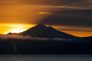 Fototapeta premium Sunrise Over the Active Volcano, Mt. Baker, in the North Cascade Mountain Range. Mt. Baker is one of the snowiest places in the world and is located 31 miles east of Bellingham, Washington.