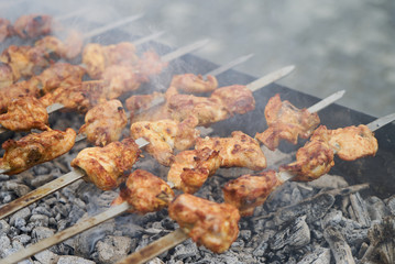 Roasted chicken wings kebab on skewers, close-up, outdoors.
