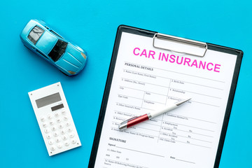 Car insurance concept with form, car toy and calculator on blue background top view