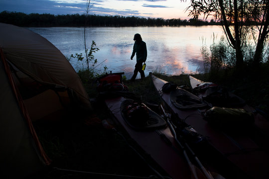 A woman walks the river bank of the Amur river in far East Russia before taking rest for the evening in camp.