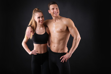 Fitness young man and woman isolated on black background.