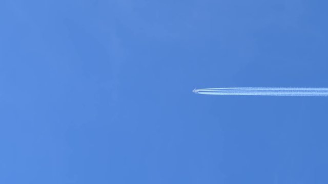 Airplane Contrail in Clear Blue Sky, Right to Left Across Frame.
