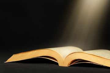 Open book with light beam and copy space