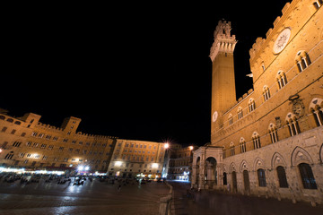 Tourists in Piazza del Campo by night, Siena, Italy. The historic centre of Siena. UNESCO World Heritage Site
