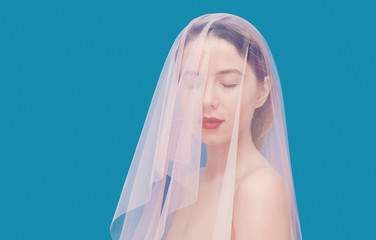 Young woman with pink tulle on blue background