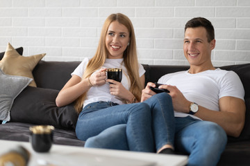 Young couple spending time together at home drinking coffee and talking.