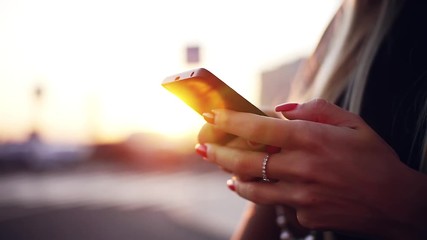 Hands young beautiful woman with red nails use phone at sunset on a summer day smartphone girl mobile modern technology telephone texting touch using adult attractive looking message close up