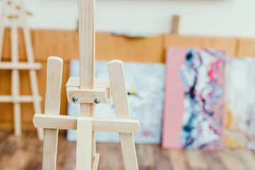 Fototapeta na wymiar selective focus of wooden easel in painting studio