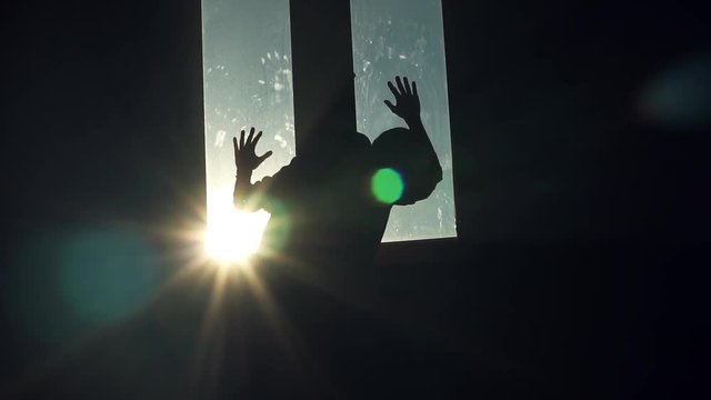 Suicide silhouette young man stand near window walk sad nervous thinking fall sunset sunlight shot back in room dark close up slow motion
