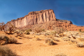 Monument Valley famous rock formations under a blue sky.