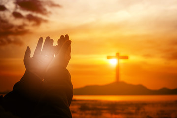 Christian woman praying worship at sunset. Hands folded in prayer. worship god with christian...