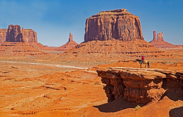 A Native American on horseback in a scenic view in Monument Valley.