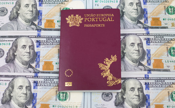 Portuguese passport (Translation "European Union Portugal passport") and one hundred dollar banknotes background