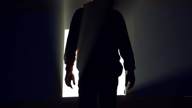 Close up silhouette man stand near window in dark sunshine jalousie installing apartment interior inside sunlight view closeup flat slow motion