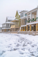 Snowy path with footprints and homes in winter