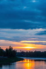 Fototapeta na wymiar Sunset over Uzh river in Uzhhorod city, Transcarpathia region, Ukraine. Beautiful cityscape of old european town