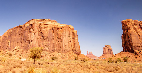 Monument Valley famous rock formations under a blue sky.