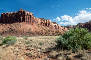 Monument Valley famous rock formations under a blue sky.