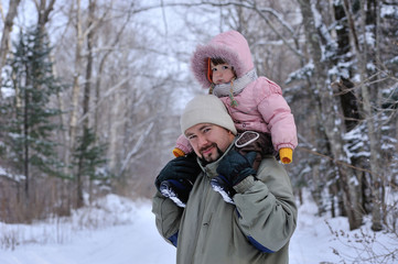 portrait of father with little doughter on shouldres in winter forest - 257559534