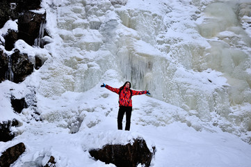 happy girl standing on the top above frozen waterfall - 257559552