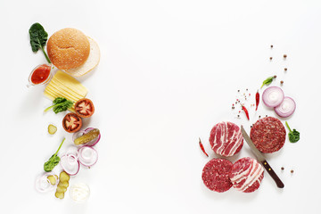 Meat and a variety of burgers on a white background. Top view. Space for text.