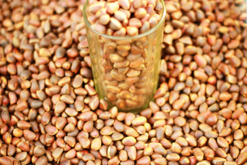 glass glass with pine nuts on a heap of walnut