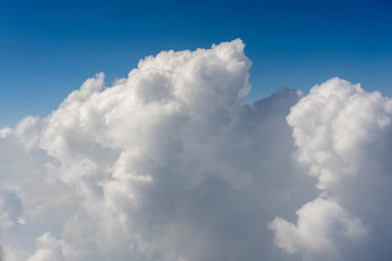 Fototapeta na wymiar White clouds and blue sky, a view from airplane window