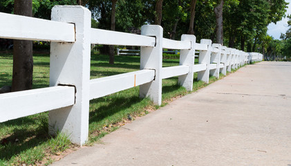 Row of white fence along the concrete road