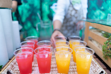 Orange juice squeezed with red juice that is inserted into the glass and placed in a wooden tray