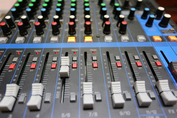 Audio mixer control panel with buttons and sliders.