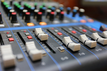 Audio mixer control panel with buttons and sliders.