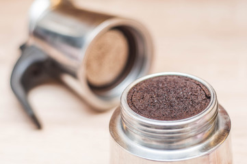used coffee grounds after making your morning coffee in a coffee maker with a mesh with a blurred light background