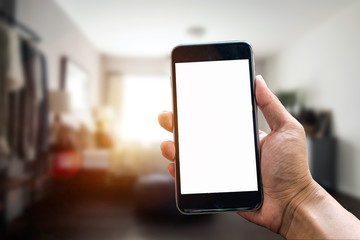 A man hand holding smart phone device in the bright office room interior.