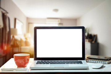 Fototapeta premium Front view of cup and laptop, smartphone, and tablet on table in office and background 