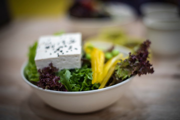 Salad bowl with soft tofu and black seed placed on top.