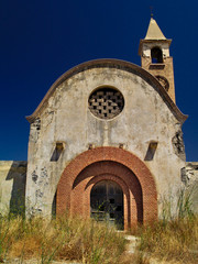 Fototapeta na wymiar St Mark catholic church in Kattavia, Rhodes island, Greece. Summertime, vivid blue sky, abandoned temple.