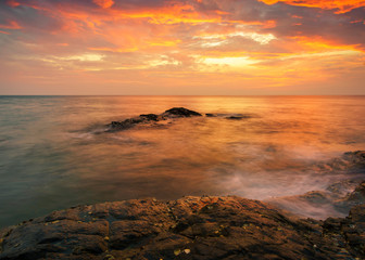 Naklejka premium Beautiful Tropical seascape wave hit the rock during sunset