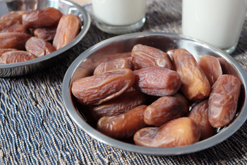 Bowl of dates fruits and glass of milk, usually consumed when break fasting