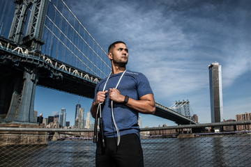 Athlete man with jump rope ready for outdoors workout in New York City