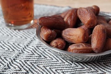 Bowl of dates fruit and glass of tea, usually consumed when break fasting