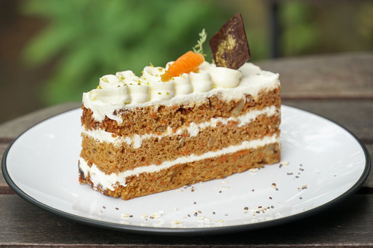 Delicious sliced carrot cake on wood table.