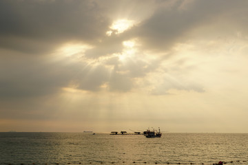 Fishing boat in the sea at sunset sky.