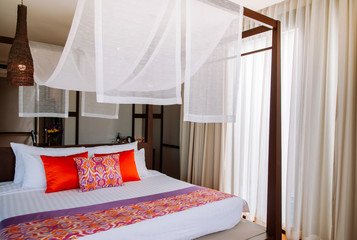Asian tropical hotel room with four poster bed