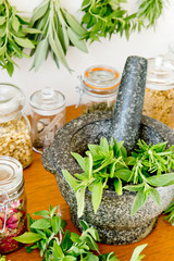 Herbal Apothecary jars, fresh herbs and stone mortar and pestle